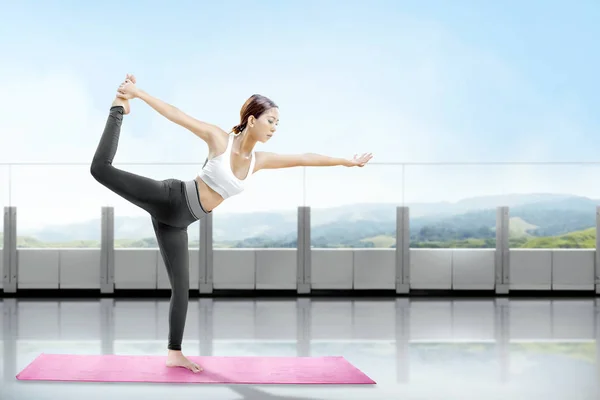 Asiatico donna sana praticare yoga sul tappeto in terrazza — Foto Stock