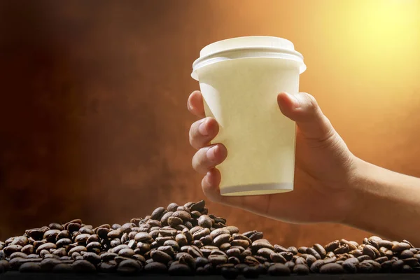 Ruční pěnový šálek s horkou kávou a kávovou fazolí na t — Stock fotografie