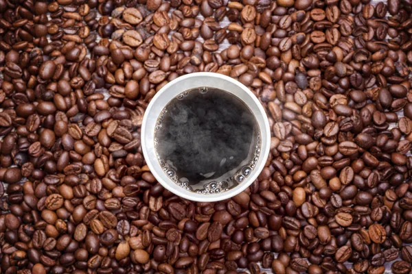 Pěnový šálek horké kávy s kávovou fazolí — Stock fotografie