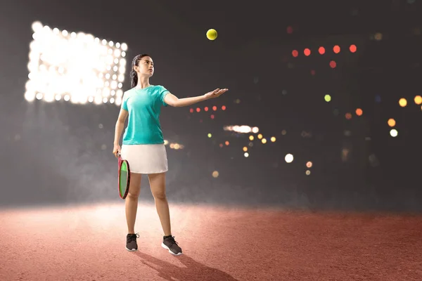 Asiatisk kvinna med tennisracket i händerna redo i serve POS — Stockfoto