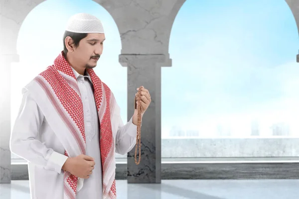 Азіатські людина мусульманин стоячи і молитися з молитвою бісером — стокове фото