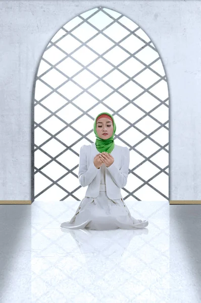 Mulher muçulmana asiática em véu sentada em posição de oração enquanto levantada — Fotografia de Stock