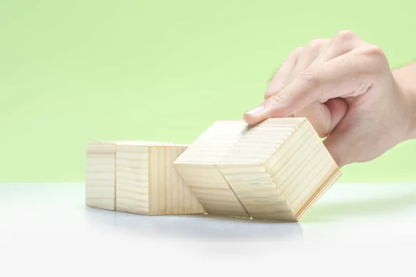 Mano che gioca con blocco di legno sul tavolo — Foto Stock