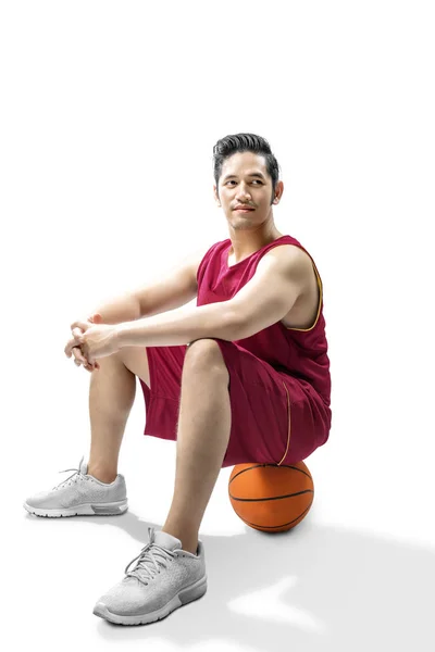 Asiatischer Basketballspieler sitzt auf dem Ball — Stockfoto