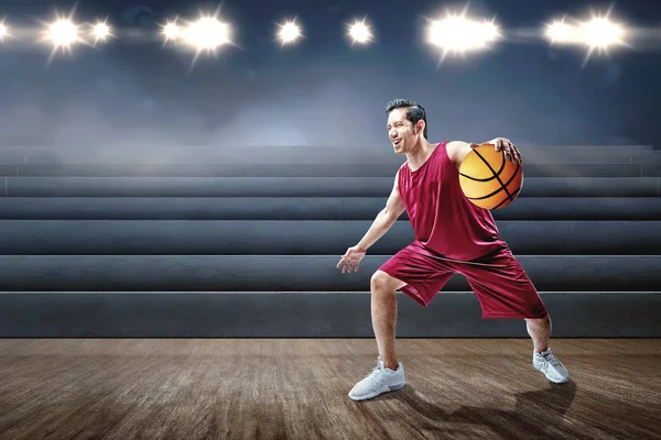 Asiatisk mand basketball spiller spiller basketball - Stock-foto