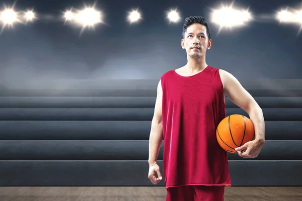 Asiatisk man basketspelare håller bollen på sin hand — Stockfoto