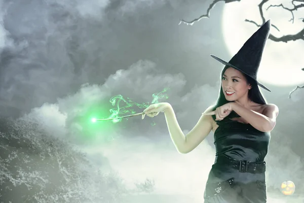 Mulher bruxa asiática usando a varinha com brilho mágico — Fotografia de Stock