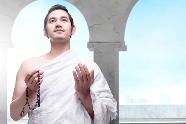 Asian Muslim man in ihram clothes standing and praying with pray — Stock Photo, Image