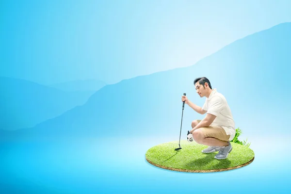 Asiático hombre con putter golf agacharse y mirar a una distancia — Foto de Stock
