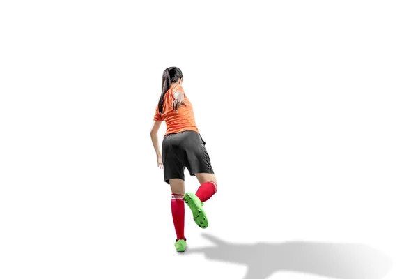 Zadní pohled na asijskou fotbalistou ženu v pozici kopání — Stock fotografie