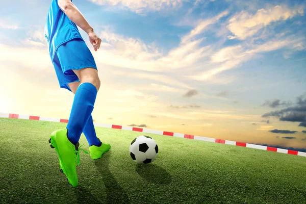 ボールを蹴るサッカー選手の男の背面図 — ストック写真