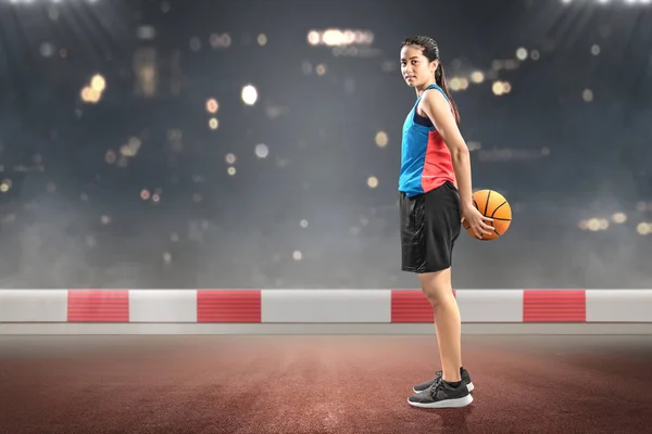 Mulher asiática jogador de basquete segurando a bola de costas — Fotografia de Stock