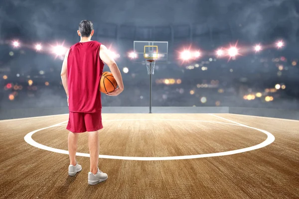 Achteraanzicht van de Aziatische man basketbalspeler het houden van de bal op zijn — Stockfoto