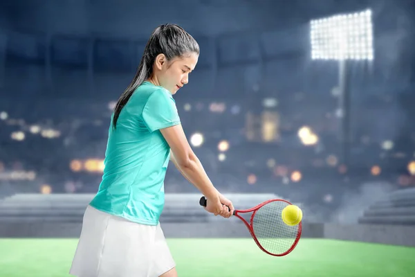 Asiatisk kvinna med tennisracket i händerna slog bollen — Stockfoto