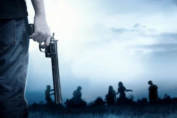 People with a gun on his hand face the zombies on the grass fiel — Stock Photo, Image