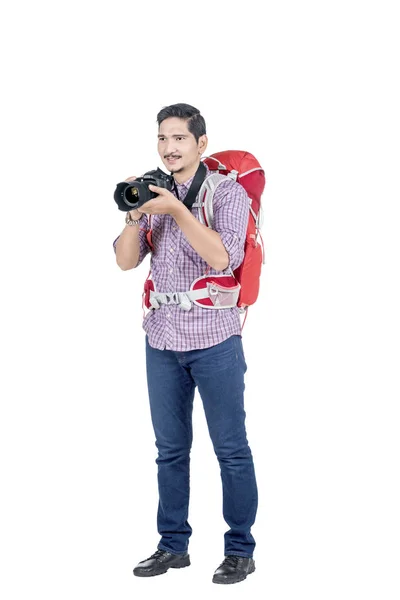 Азіатська людина з рюкзаком тримає камеру, щоб сфотографуватися — стокове фото