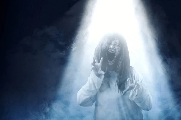 Gruselige Geisterfrau mit Blut und wütendem Gesicht mit krallendem Händchen, die im dunklen Nebel steht. Halloween-Konzept — Stockbild Gruselige Geisterfrau mit Blut und wütendem Gesicht mit krallenden Händen — Stockfoto
