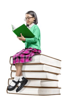 Kitap ve yeniden yığını üzerinde oturan gözlük ile Asya sevimli kız