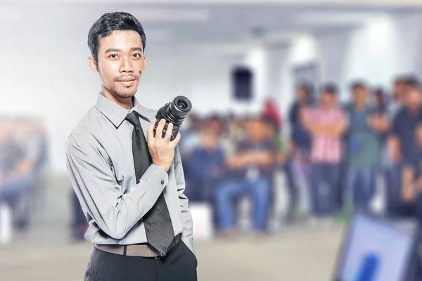 Asiático empresário segurando a câmera em sua mão — Fotografia de Stock