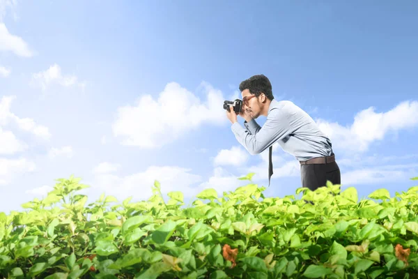 Asijský obchodník si fotil s fotoaparátem na zelené PA — Stock fotografie