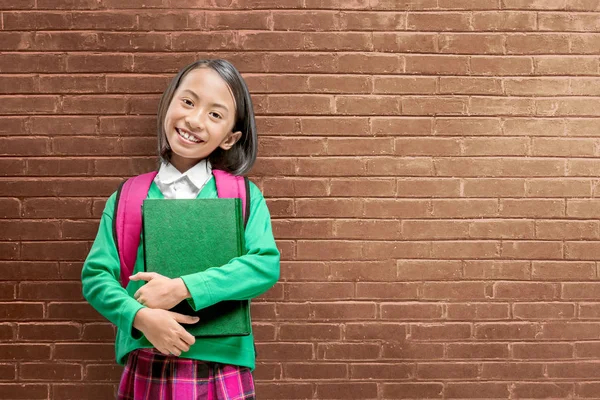 Asian cute girl z plecaka trzymając książkę stojący — Zdjęcie stockowe
