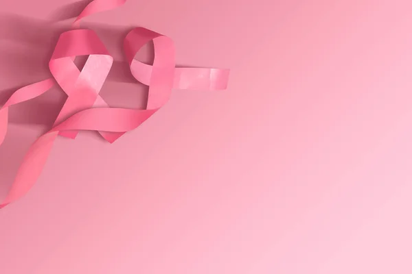 Pink awareness ribbon on a colored background — Stock Photo, Image