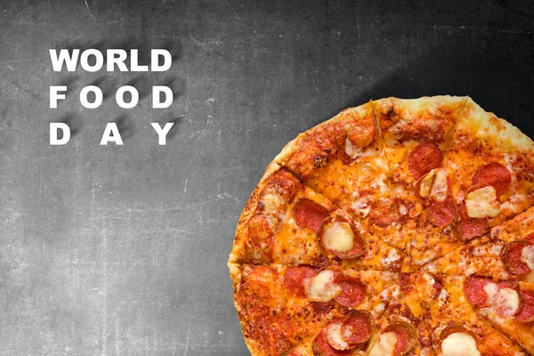 Pizza avec texte de la Journée mondiale de l'alimentation sur fond noir — Photo