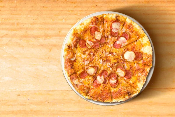 Pizza na desce na dřevěné tapetu — Stock fotografie