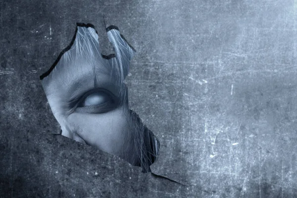 깨진 벽 뒤에 들여다 화가 얼굴을 가진 무서운 좀비 — 스톡 사진