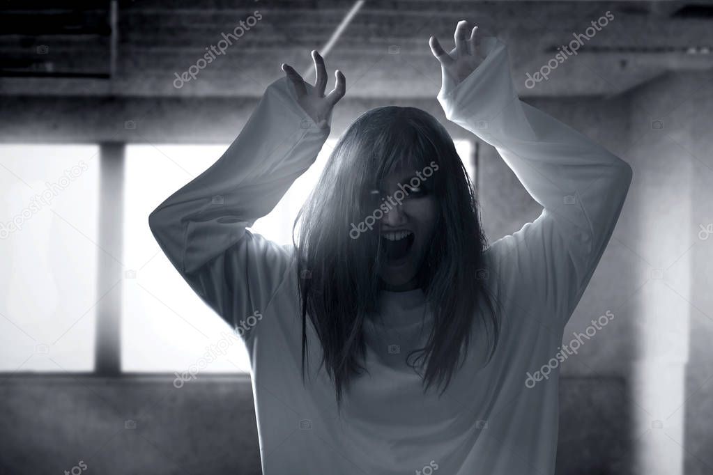 Scary ghost woman with blood and angry face with clawing hands h