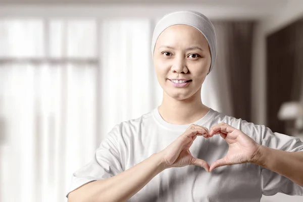 Asiática mujer en una camisa blanca mostrando un signo de corazón con sus manos —  Fotos de Stock