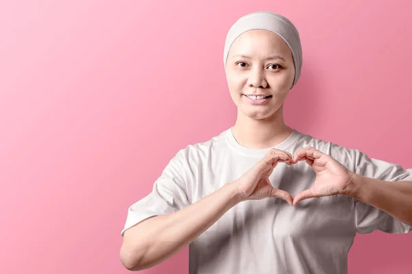 Asiática mujer en una camisa blanca mostrando un signo de corazón con sus manos —  Fotos de Stock