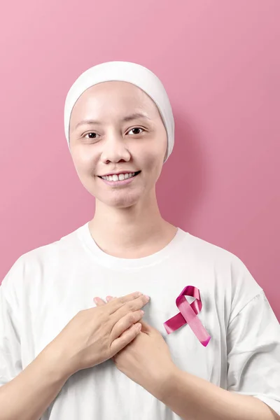 Mujer asiática en una camisa blanca con cinta rosa sobre fondo rosa — Foto de Stock