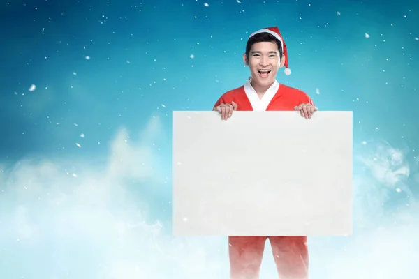 Asiatique homme dans Santa costume tenant un tableau blanc avec chute de neige b — Photo