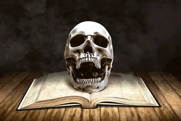 Opened book with a human skull on wooden table — ストック写真
