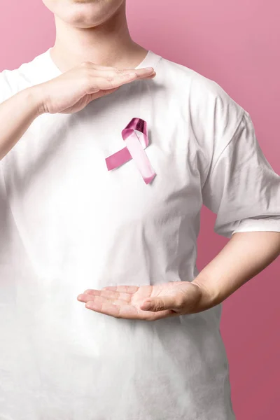 Mujer con una camisa blanca mostrando cinta de conciencia rosa sobre un rosa —  Fotos de Stock