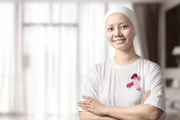 Asiatische Frau in einem weißen Hemd mit einer rosa Schleife auf dem Haus — Stockfoto