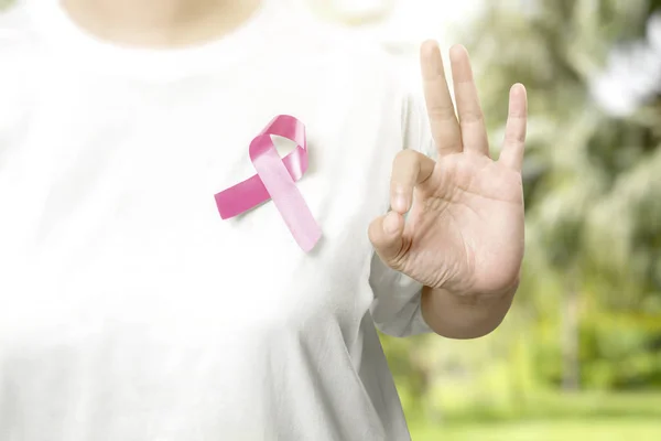 Mulher em uma camisa branca com fita rosa e mostrando OK sinal sobre — Fotografia de Stock