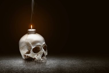 Yerde mum ve insan kafatası var.