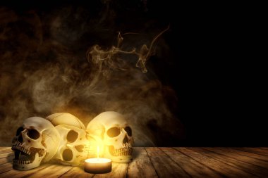 Mum ve insan kafatası ahşap masada.
