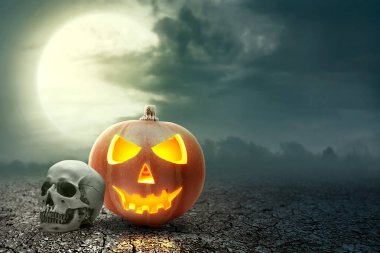 Kırık zeminde Jack-o-Lantern ve insan kafatası