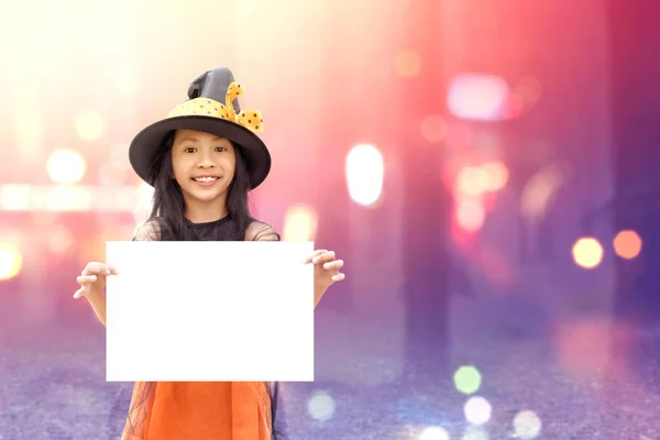 Asiatique petite fille avec sorcière costume tenant un panneau pour flic — Photo