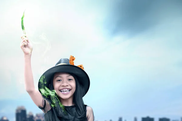 Asiático bruxa menina usando a varinha com um brilho mágico — Fotografia de Stock