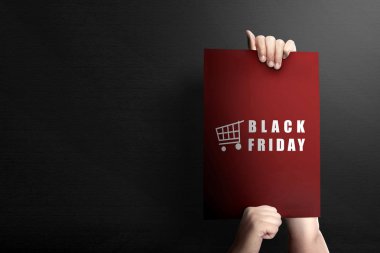 Siyah sırtında Kara Cuma yazısı olan insan elleri.