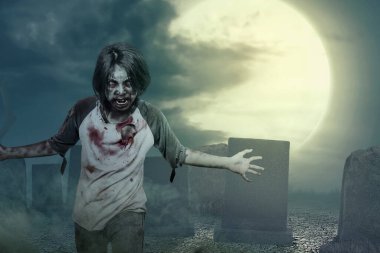 Vücudunda kan ve yara olan korkunç bir zombi mezarlıkta dolaşıyor.