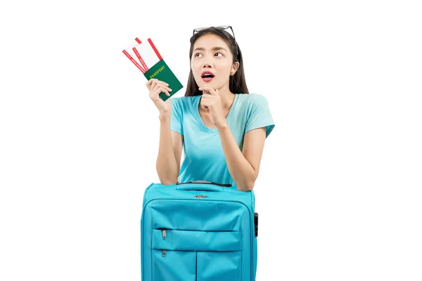 持机票和护照的亚洲妇女靠在白色背景的行李箱上 — 图库照片