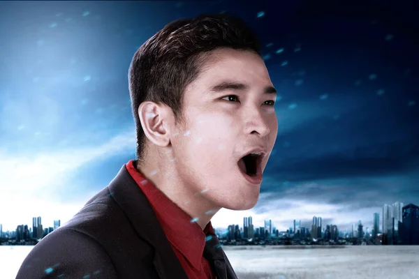 Asian businessman with an excited expression on the city with the night scene background