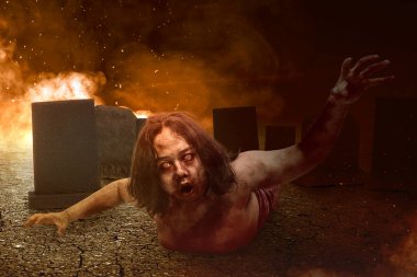 Vücudunda kan ve yara olan korkunç zombi mezarlıkta bir patlamayla sürünüyor.