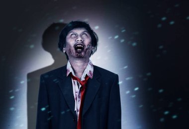 Vücudunda kan ve yara olan korkunç zombi karanlık odada duruyor.