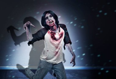 Korkunç bir zombi. Vücudunda kan ve yara var. Karanlık odada yerde sürünüyor.